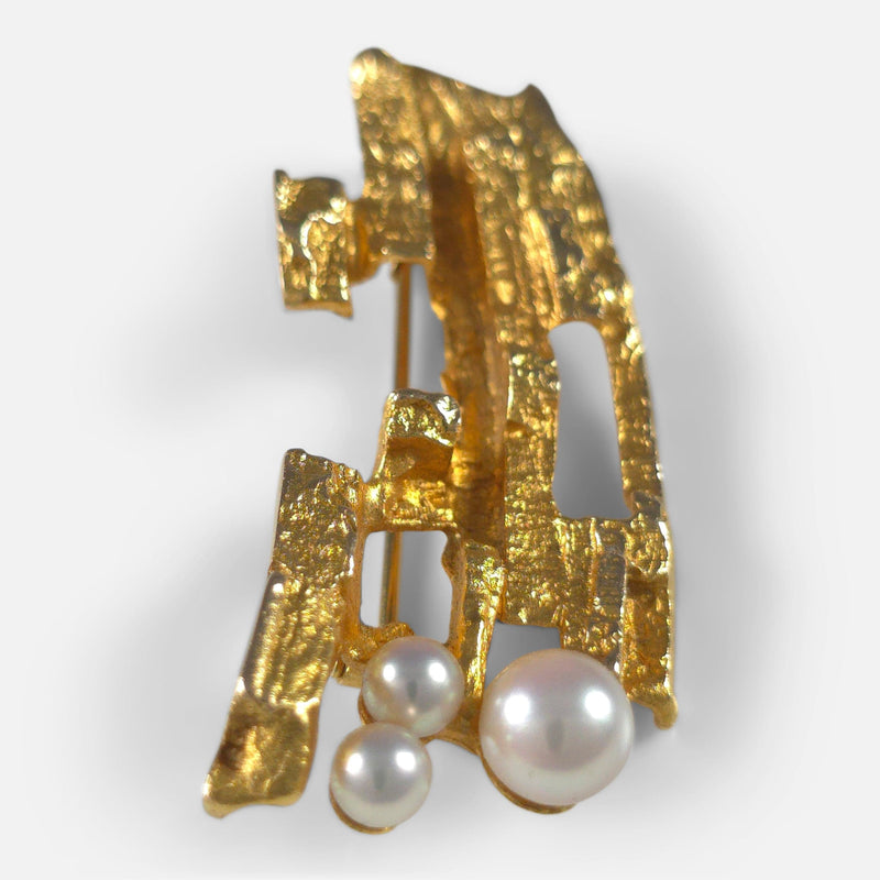 the brooch side on with pearls to the forefront